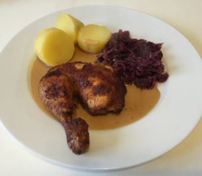 Goldbroiler mit Rotkohl und Salzkartoffeln serviert