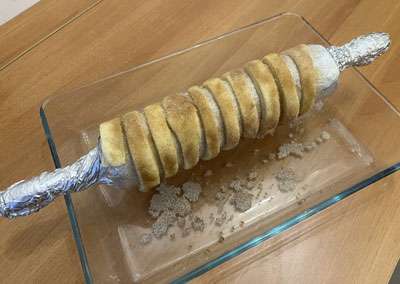 Teigstreifen um das Rollholz legen